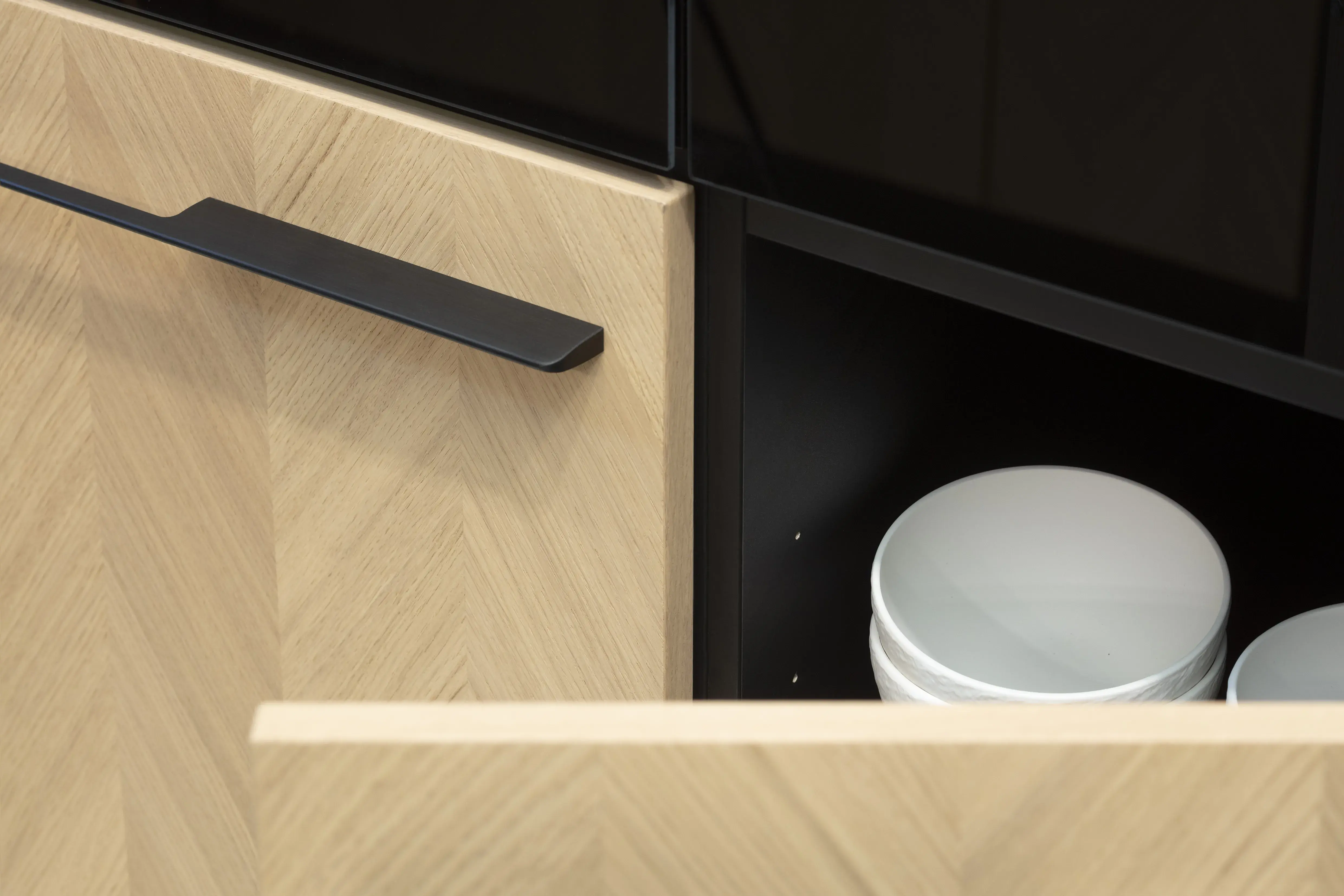 Front: Intarsia Gavi Eiche Furnier Resopal Brown Powder supermatt Korpus Schwarz APL: Resopal Brown Powder supermatt Geräte: Siemens Studio Line Spüle und Armatur: Blanco   Features: Front Echtholz Fischgrät-Optik, Kombination Echtholz und Resopal supermatt, Einbautür in Frontmaterial Resopal, Küchentheke Massivholz, APL = Korpusfarbe = Frontmaterial, Kombination Griffleiste und grifflos, Korpus in Frontmaterial, Wärmeschublade, Spüle und Armatur Schwarz, Besteckeinsatz. 